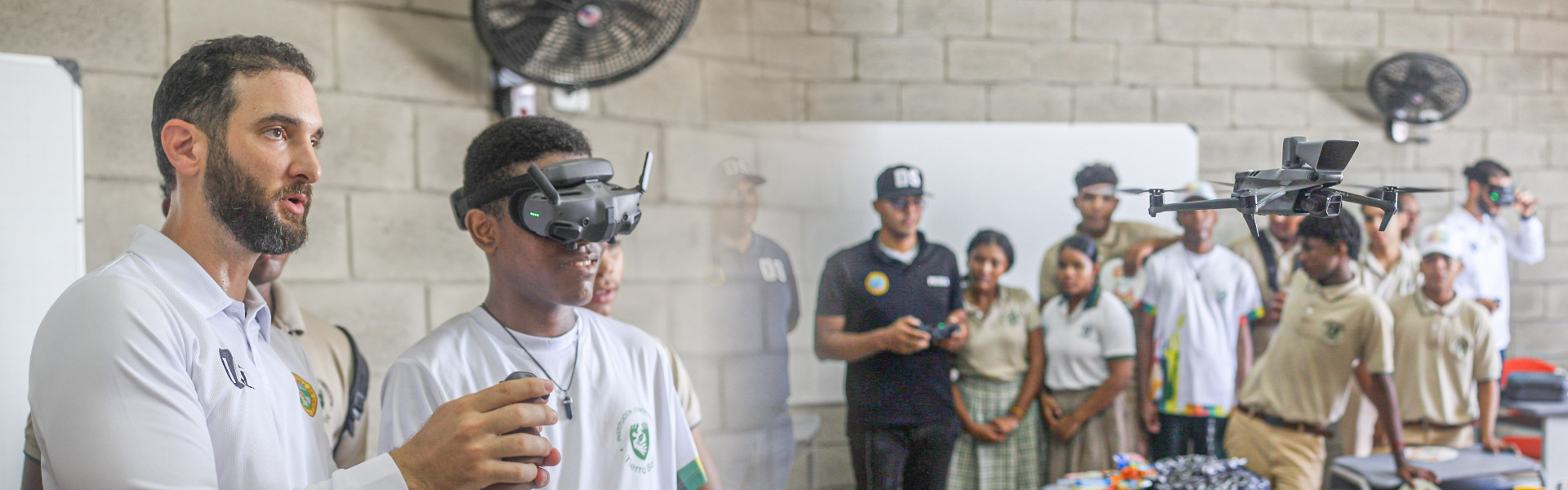 Fotografía de Director de Distriseguridad mostrando cómo funiconan los drones a estudiantes
